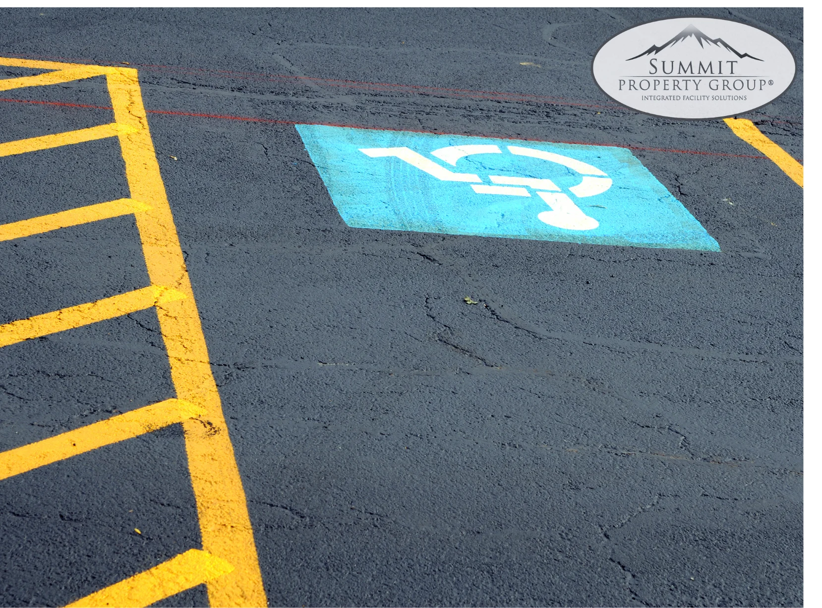 Freshly painted parking lot with yellow lines and a clearly marked blue handicap parking space, showcasing professional parking lot line painting and maintenance services in Lethbridge.