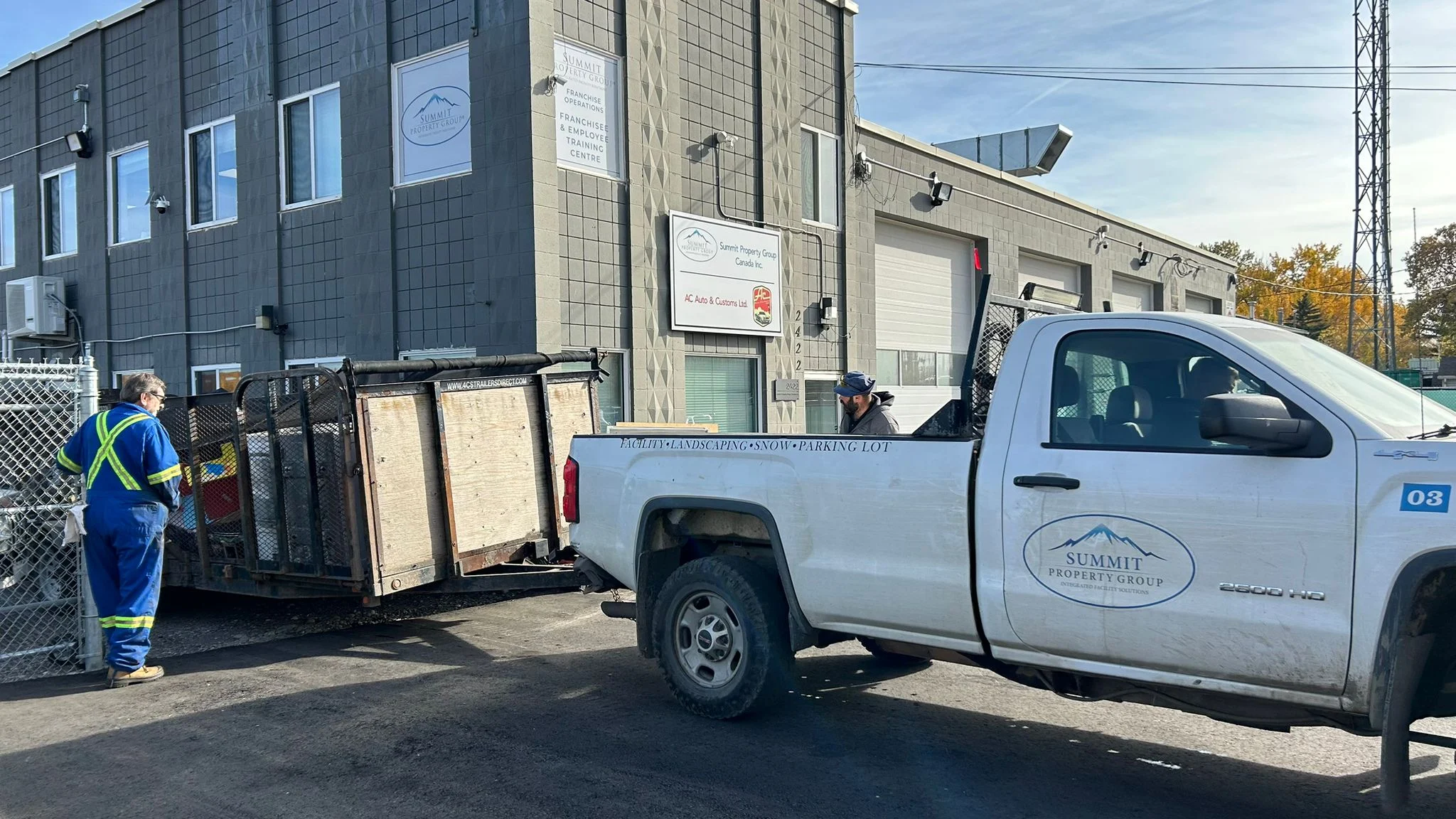 Summit Property Group truck parked outside their facility, with workers preparing equipment for landscaping, snow removal, and property management services in Lethbridge.