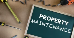 Chalkboard with the words 'Property Maintenance' surrounded by tools like a tape measure, screwdriver, and drill, symbolizing professional property upkeep services